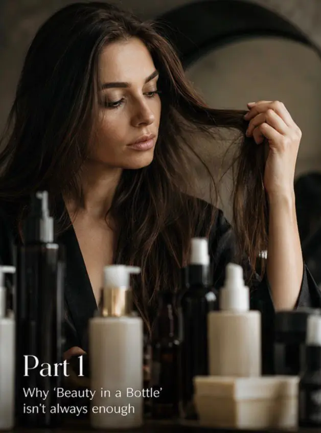 Woman with slight thinning at her middle part as a stylist gently combs her hair in a bright, modern salon